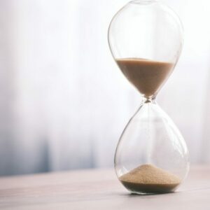 An hourglass with sand sifting through to the bottom.