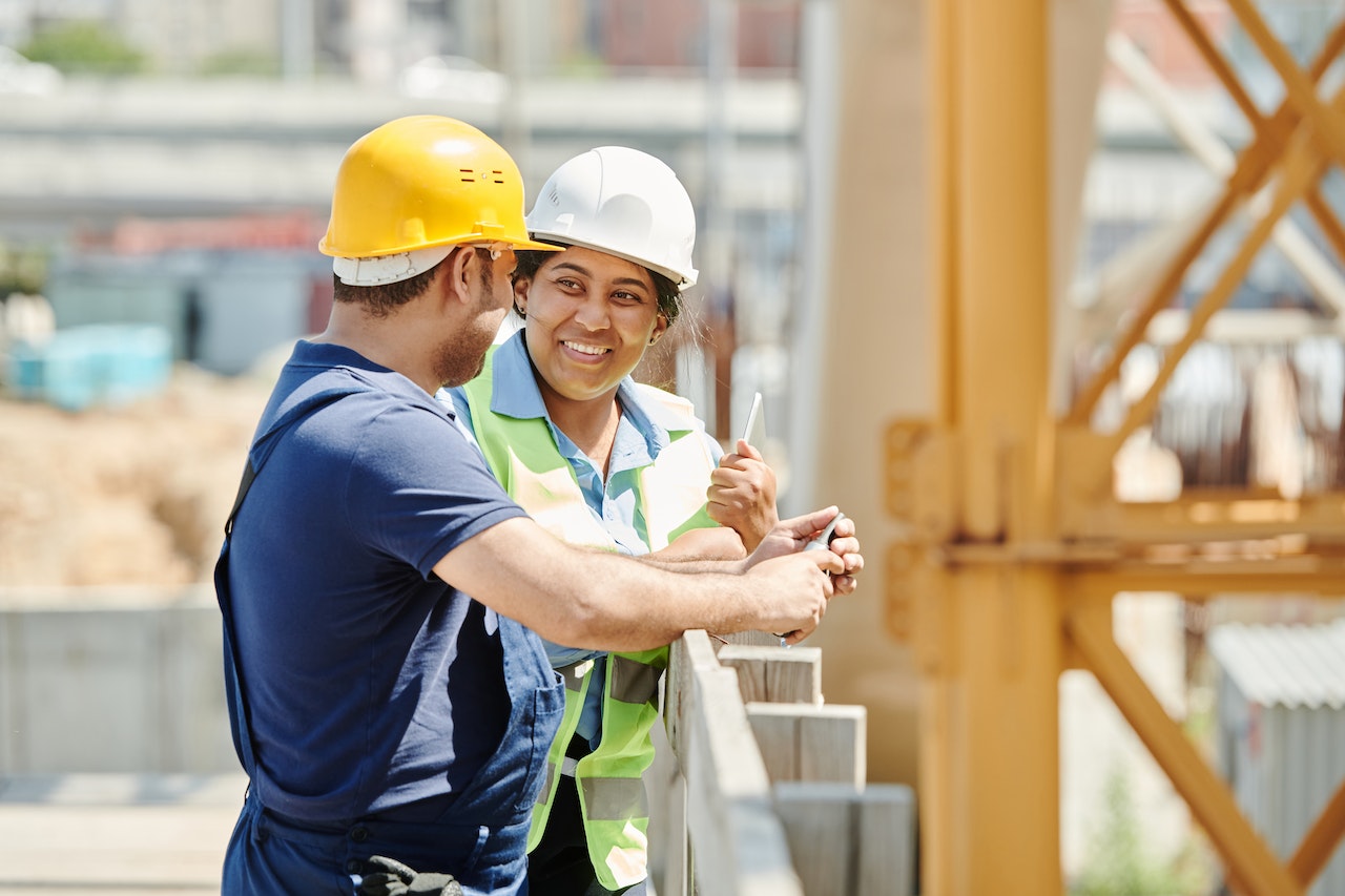 A crew leader and construction worker talking at job site.